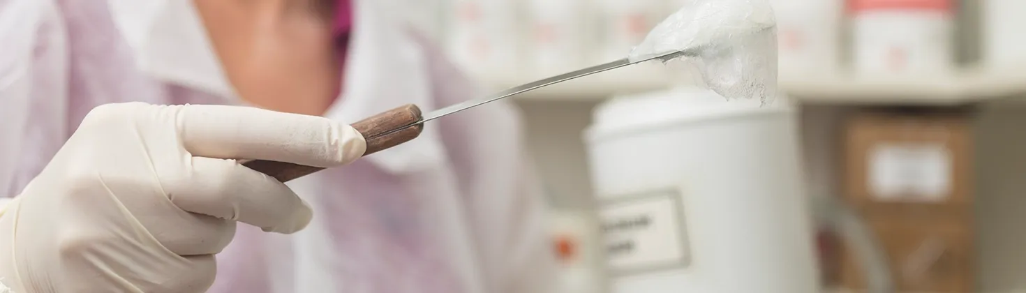 Apothekenlabor. Mit dem Spartel wird eine Substanz aus einem Glas entnommen. 